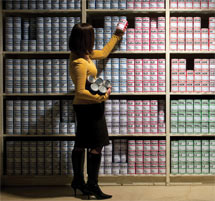 (Photo - woman scanning shelf of canned data)