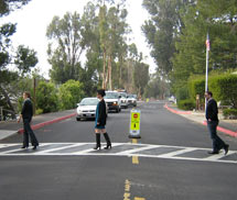 (Photo - cars stopped for pedestrians at a crosswalk)